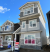 A newly constructed three-storey home with eight "for sale" realtor signs out front.